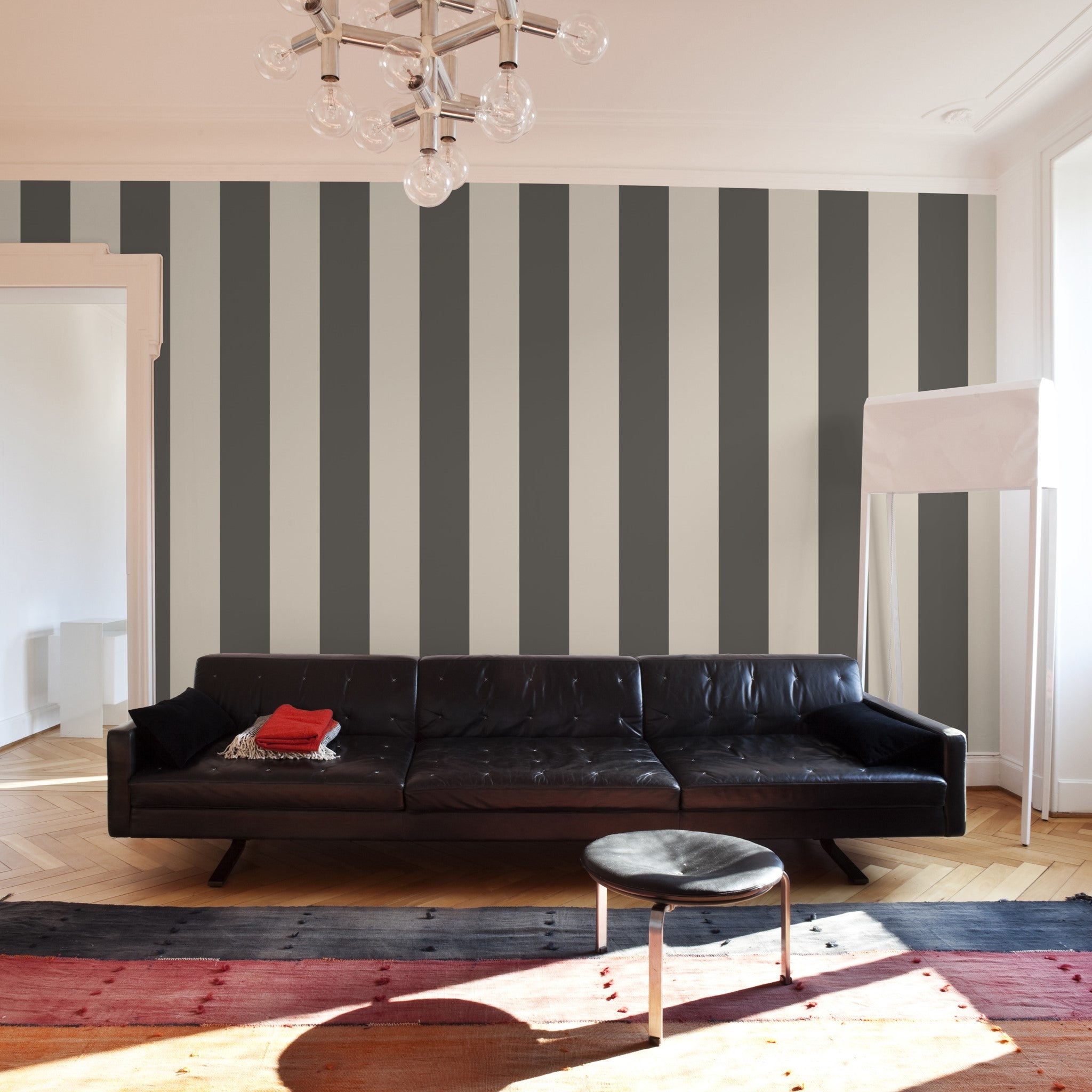 "Modern living room featuring Aldo Wallpaper by Wall Blush with striking gray stripes, focus on wallpaper design."