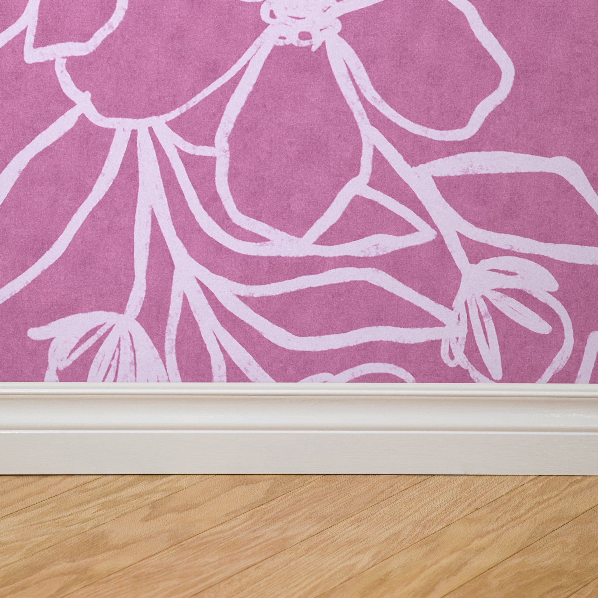 "Wall Blush's Paige (Pink) Wallpaper featured in a stylish room, highlighting elegant floral patterns on the wall."