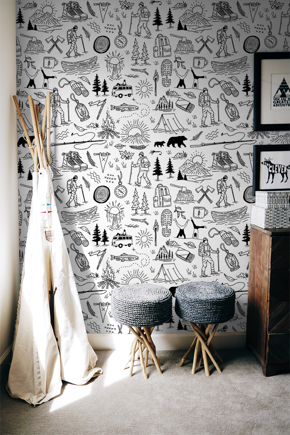 Black and white adventure-themed wallpaper with camping motifs in a cozy room.