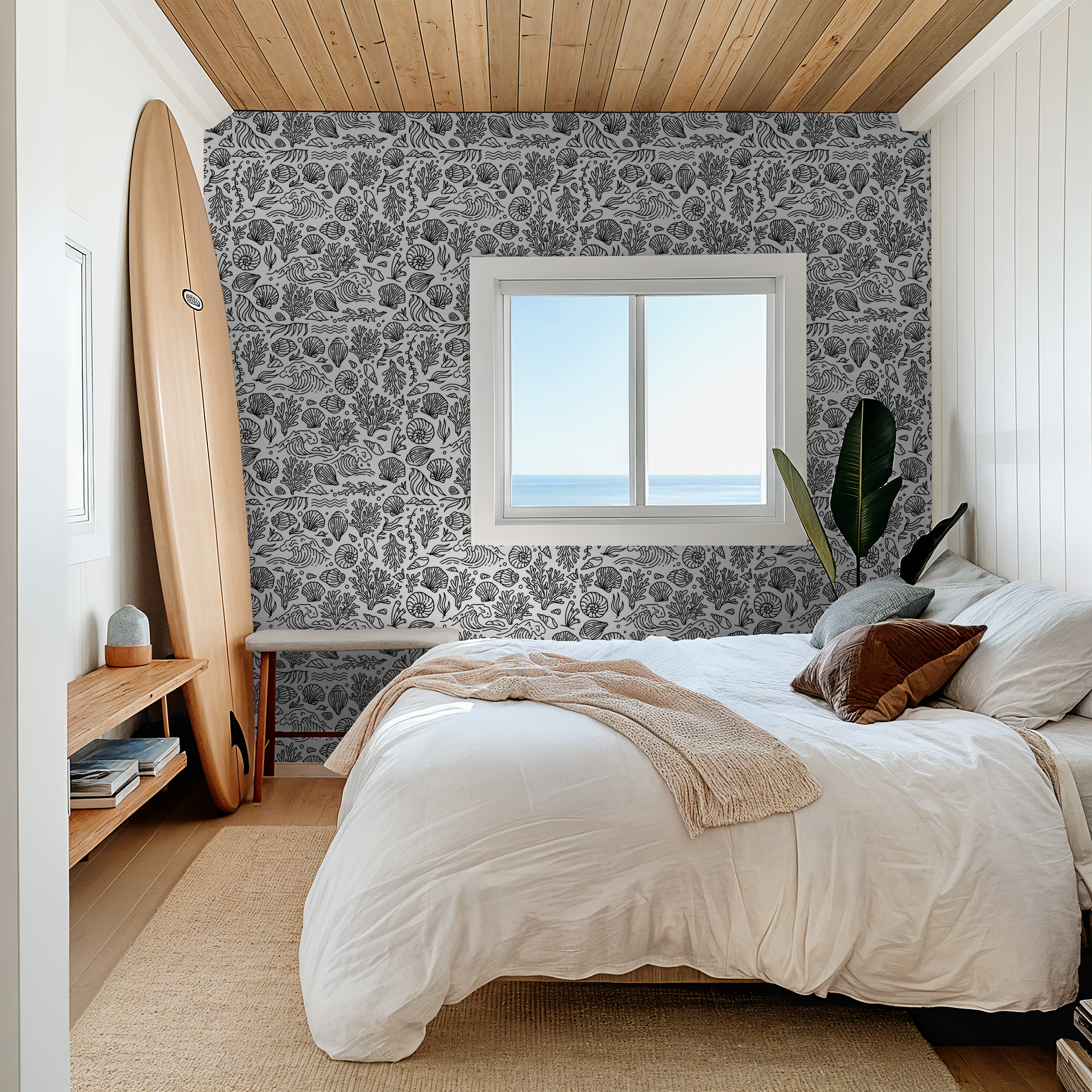 Black and white marine motif wallpaper in coastal bedroom with surfboard and ocean view.