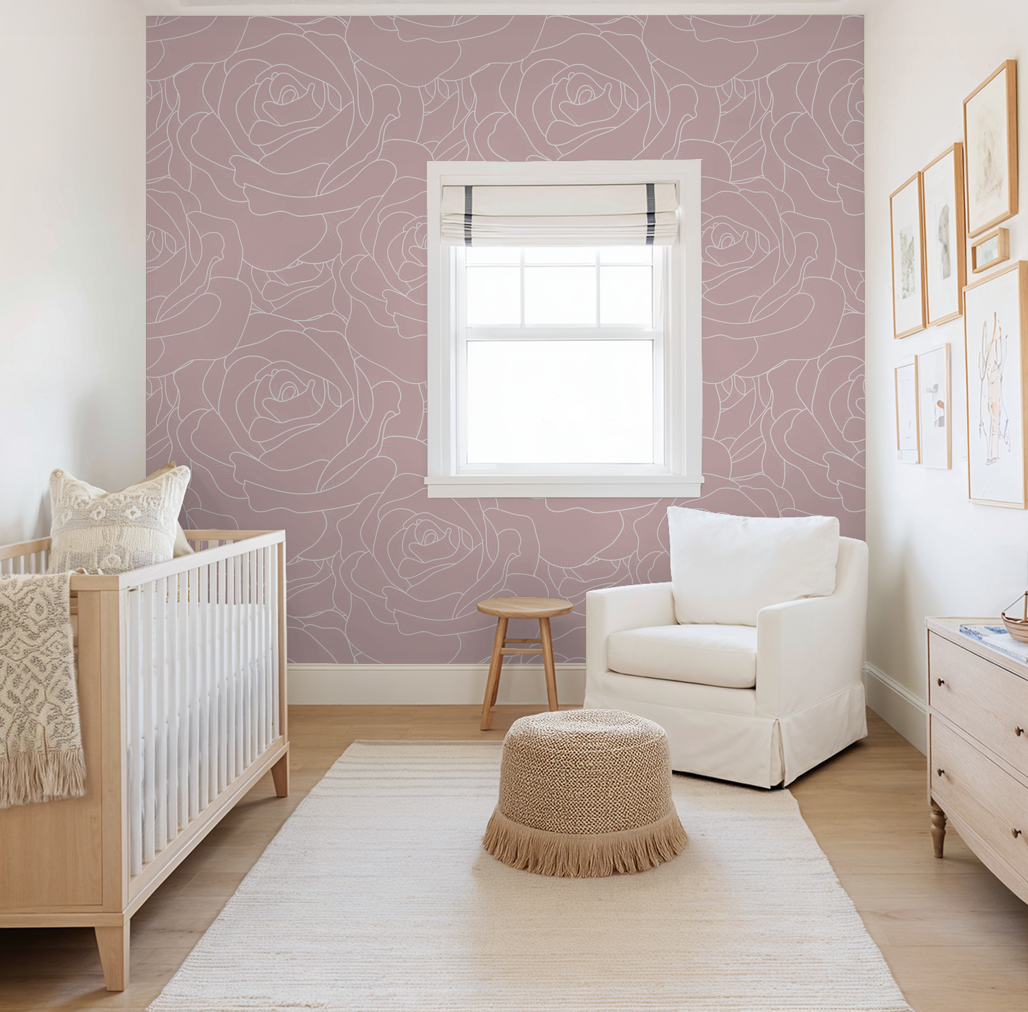 Blush pink floral rose wallpaper in a modern nursery with crib and armchair.