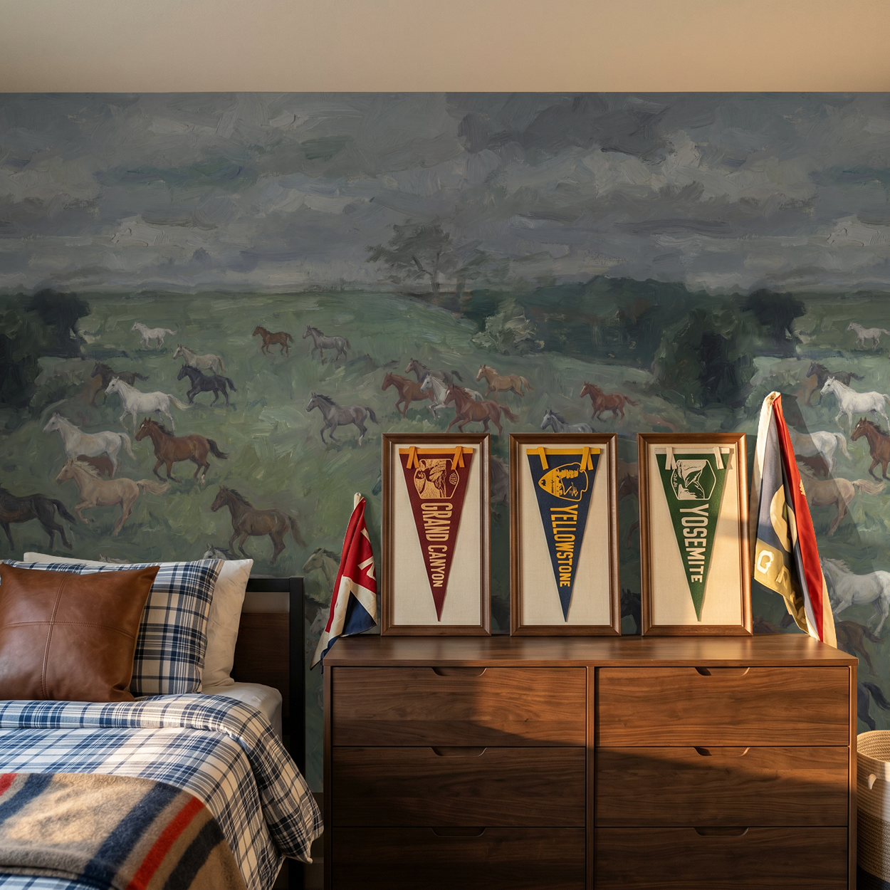 Rustic wallpaper with horses in meadow behind wooden dresser in bedroom.