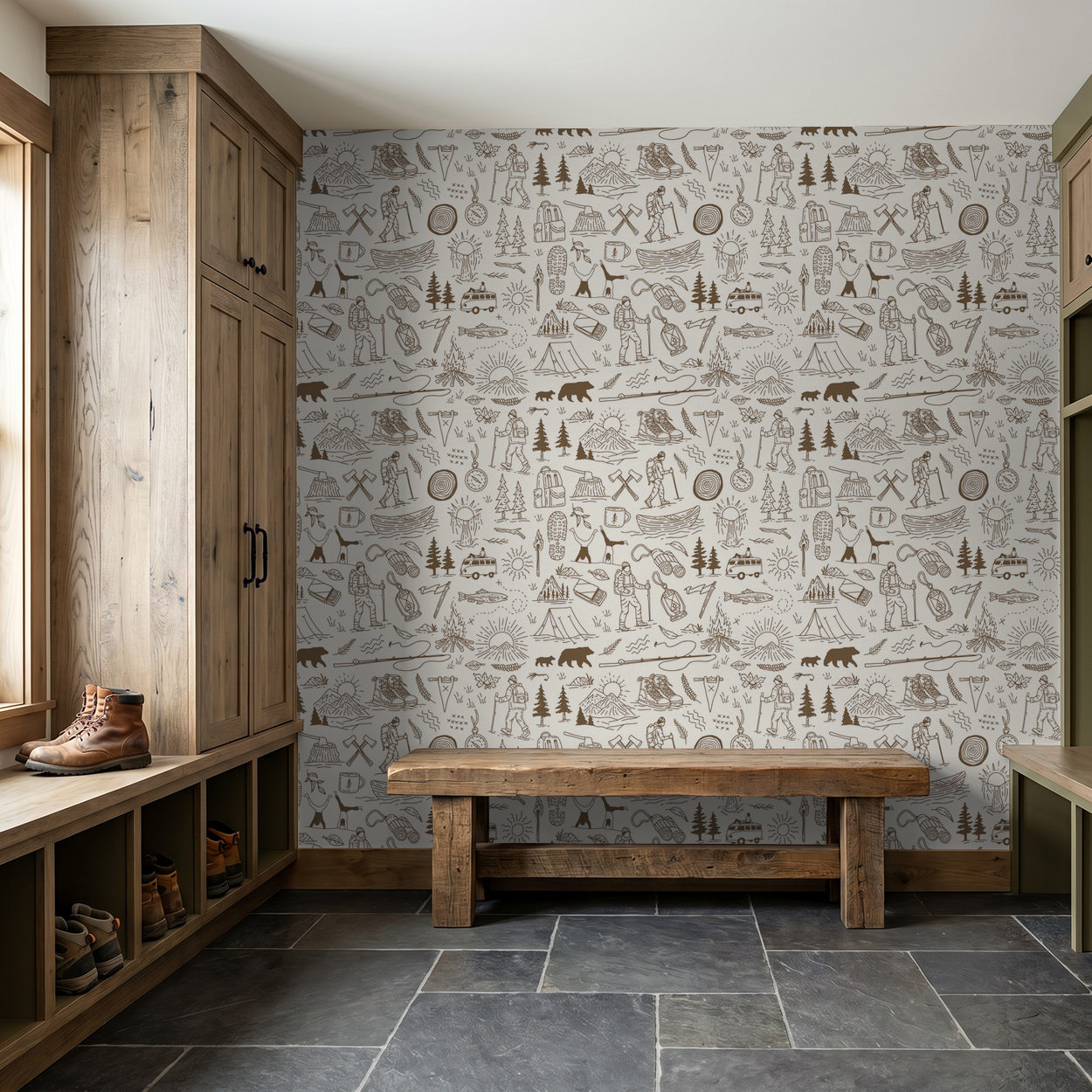 Brown and cream adventure-themed wallpaper in rustic mudroom with wooden bench and cabinets.
