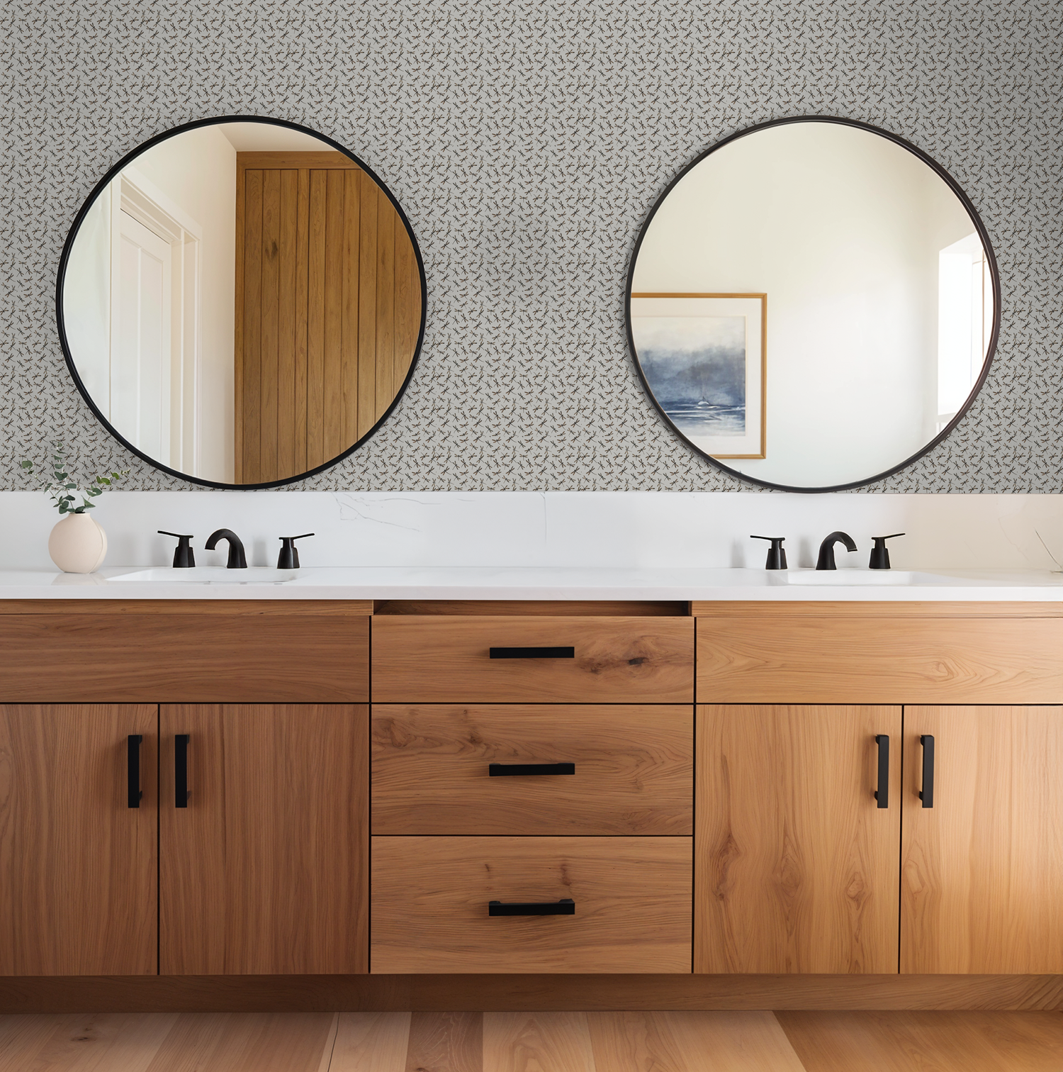 Cream dragonfly patterned wallpaper in modern bathroom with wooden cabinets and round mirrors.