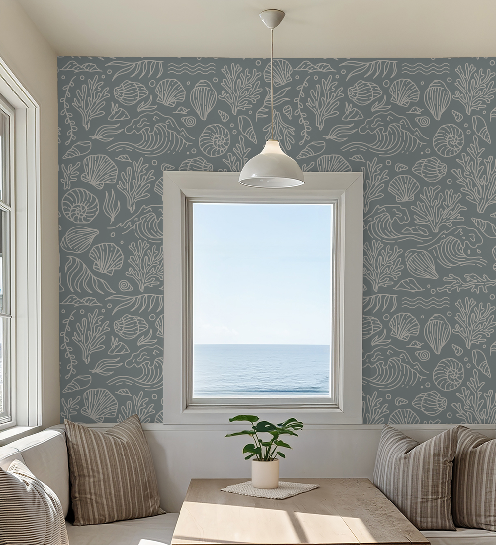Dusty blue coastal wallpaper with seashells and coral in a seaside dining room.