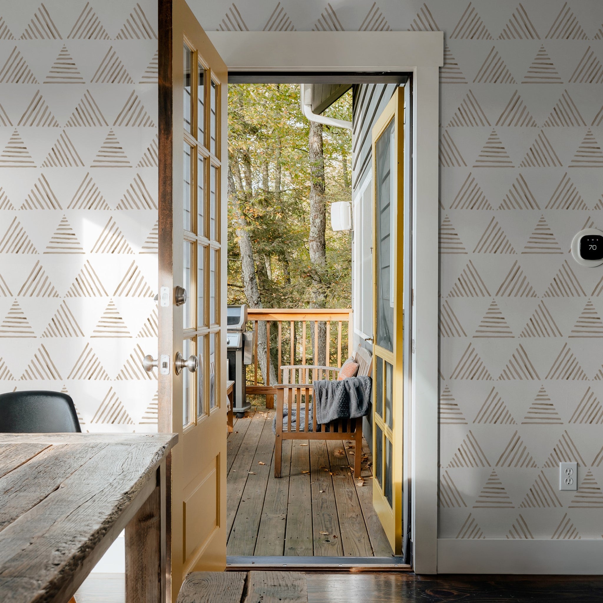 "Wall Blush's Love Triangle Wallpaper featured in a cozy, modern home office with a view of the forest."
