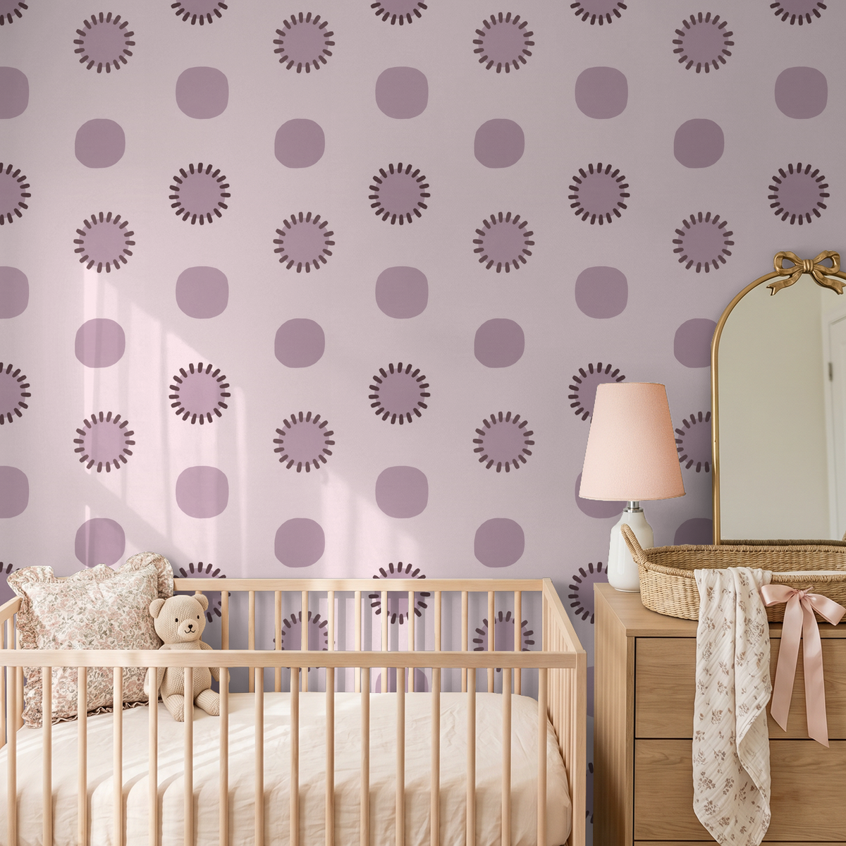 Mauve circle pattern wallpaper in nursery with crib and dresser.