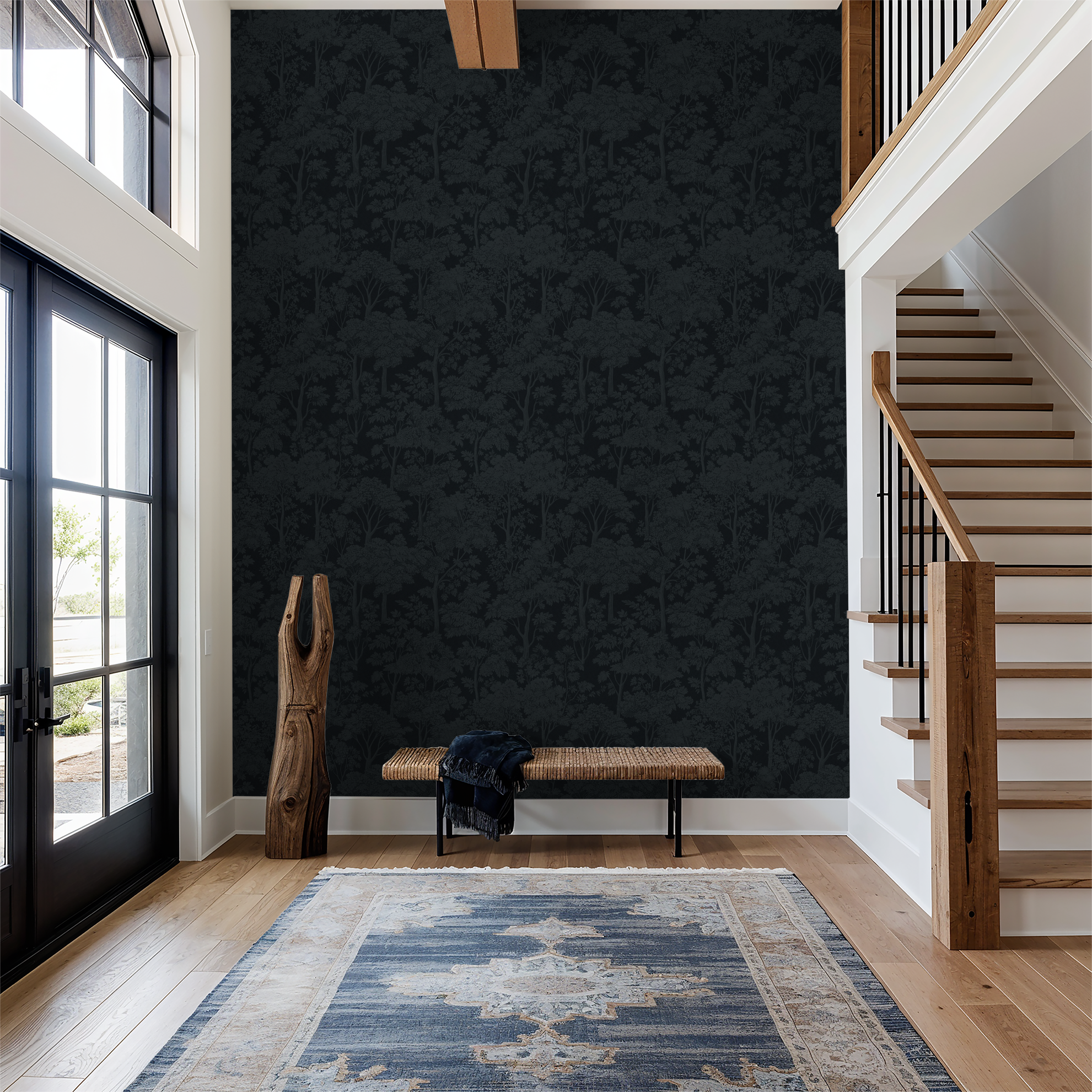 Navy tree silhouette wallpaper in modern entryway with wooden stairs and rug.