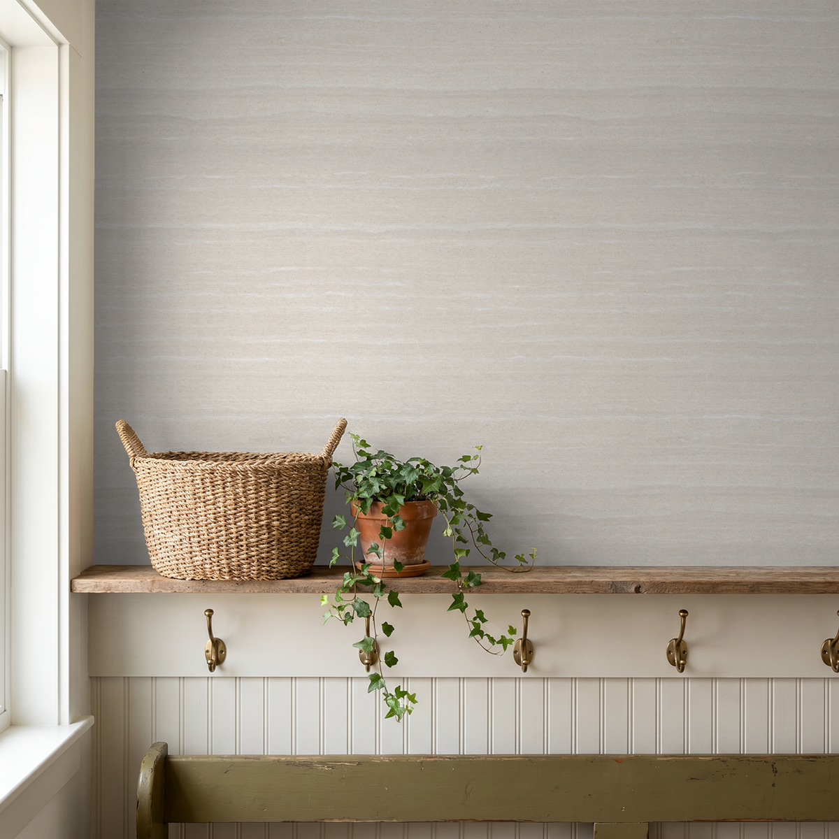 Neutral textured wallpaper in a cozy entryway with wicker basket and plant.