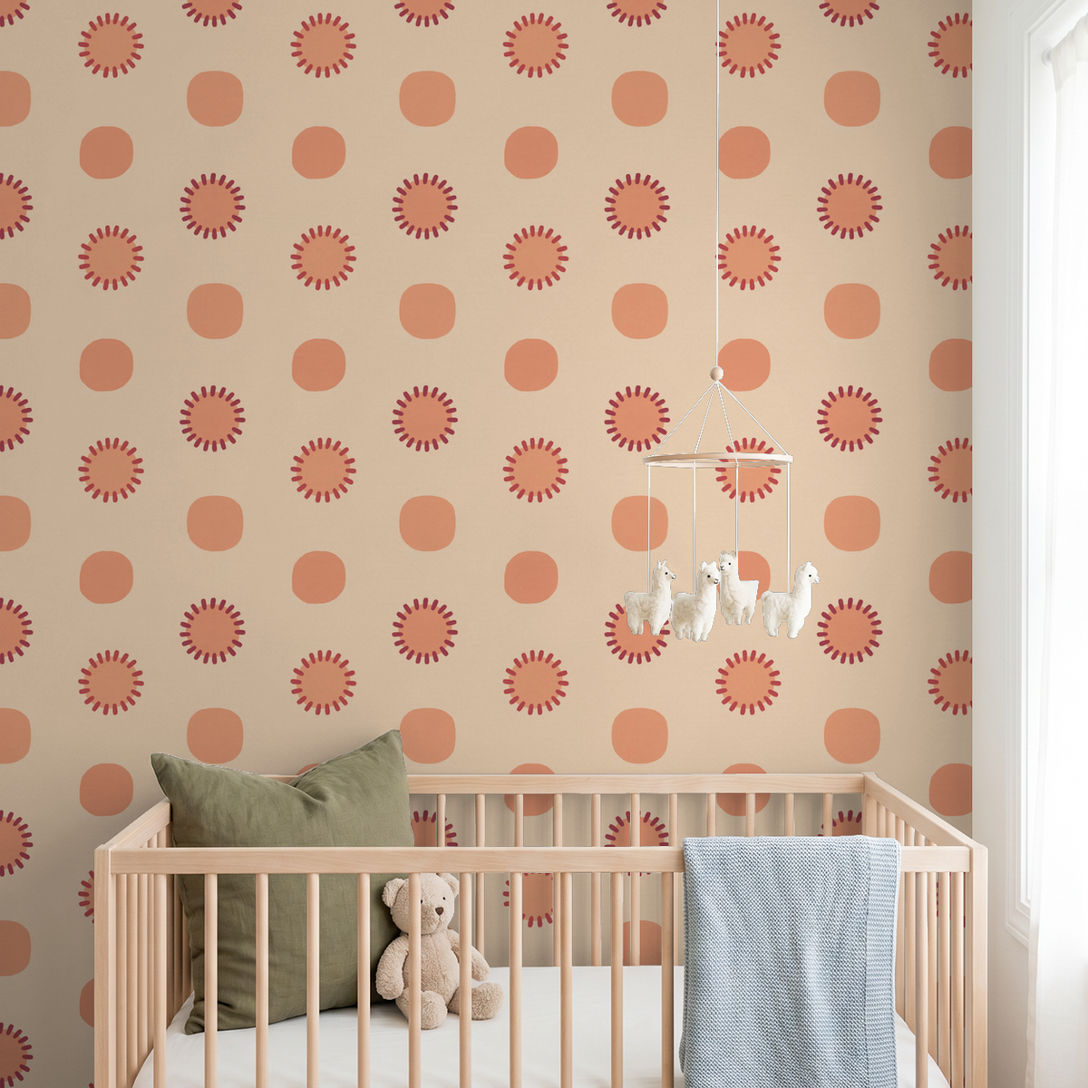 Peach circle and sunburst wallpaper in a nursery with a crib and plush toys.