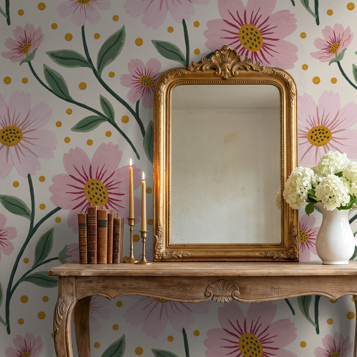 Pink floral wallpaper with gold accents, vintage mirror, and wooden table decor.