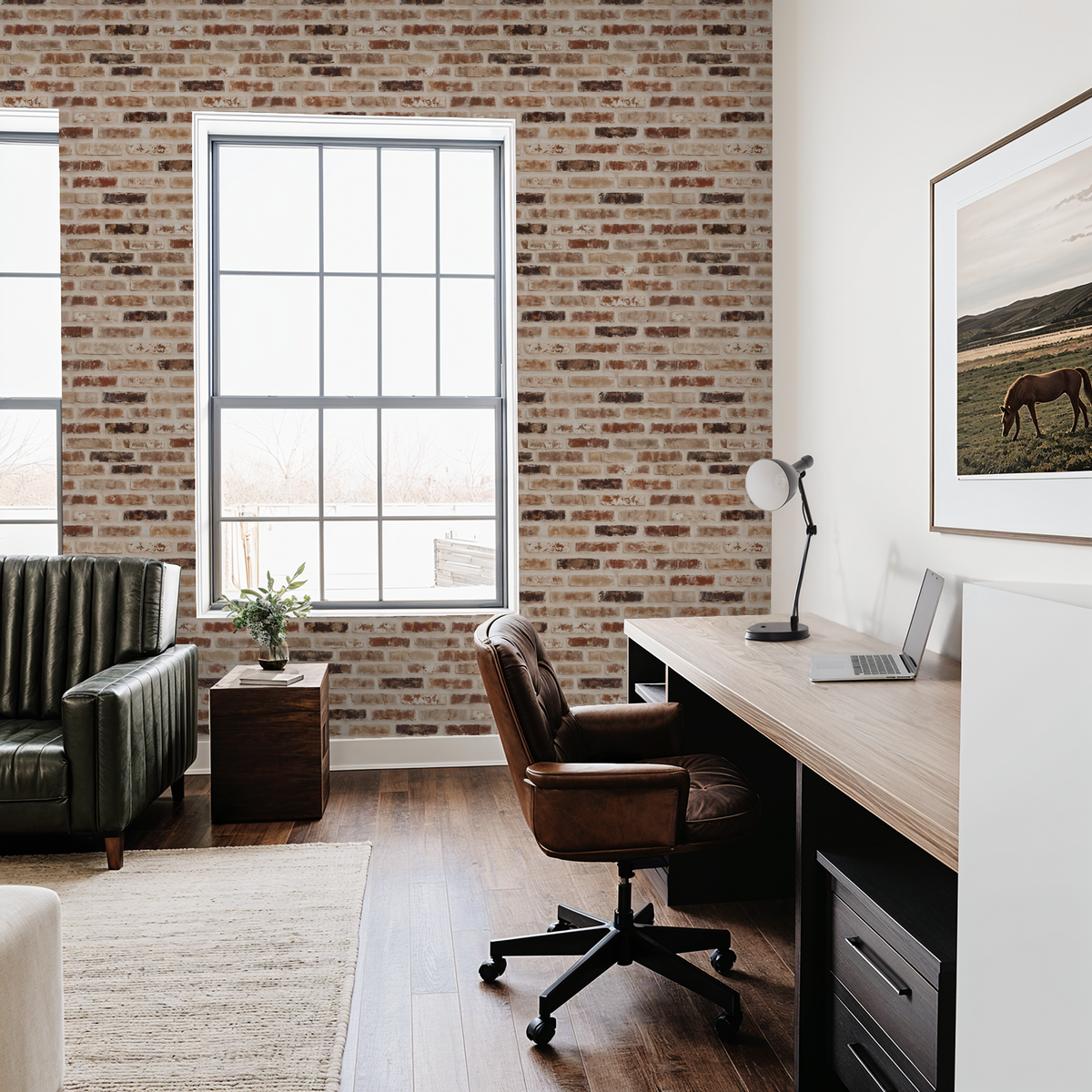 Rustic brick wallpaper in cozy office with leather chair and wood desk