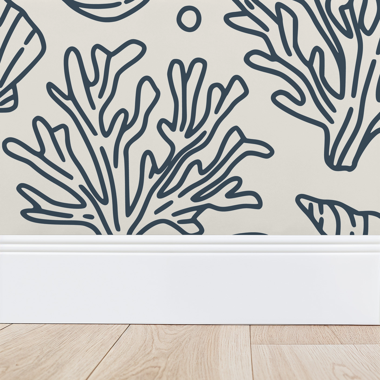 Slate blue coral pattern on cream wallpaper with baseboard and wood floor.