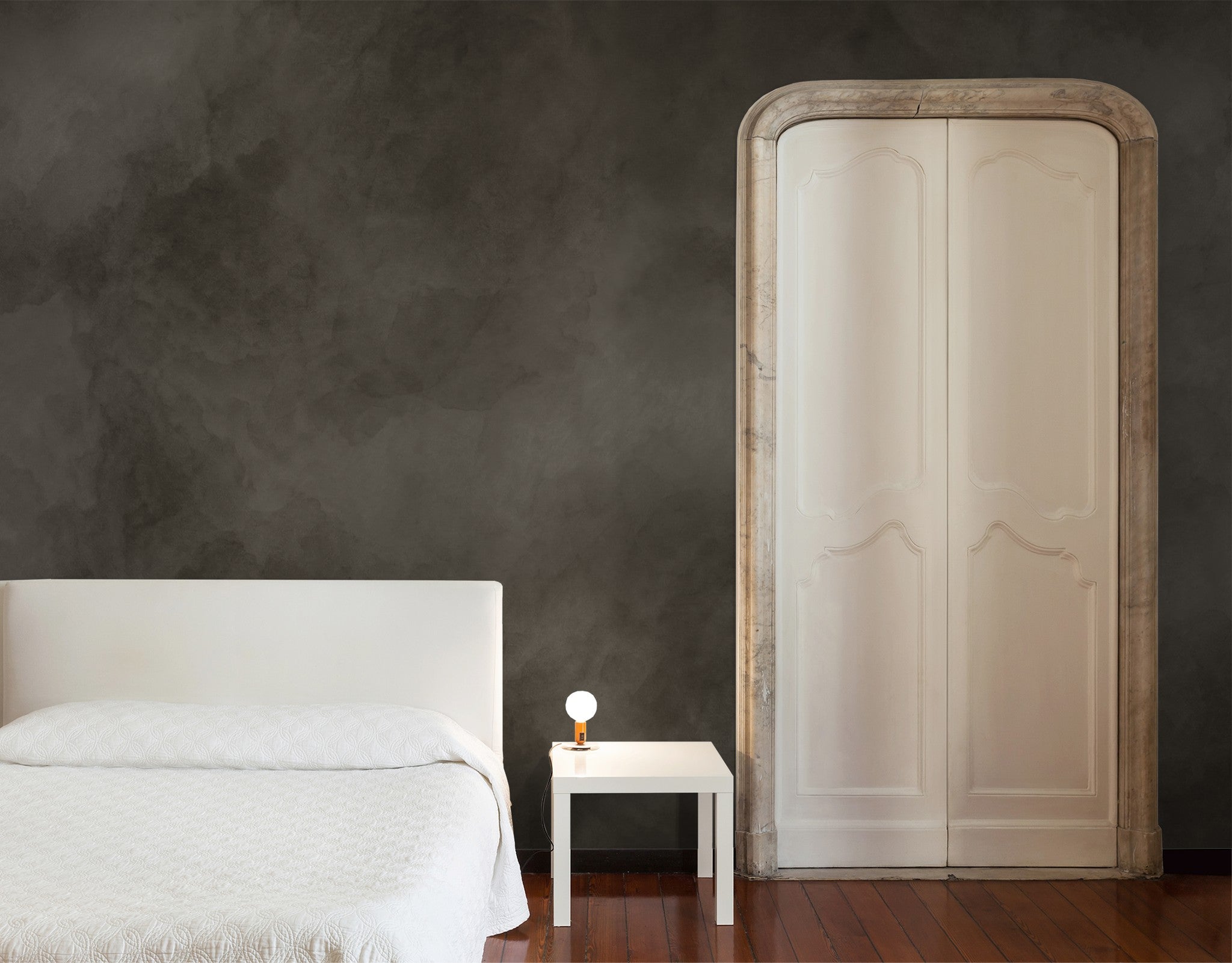 Taupe abstract cloud wallpaper in minimalist bedroom with white bed and wooden floor.