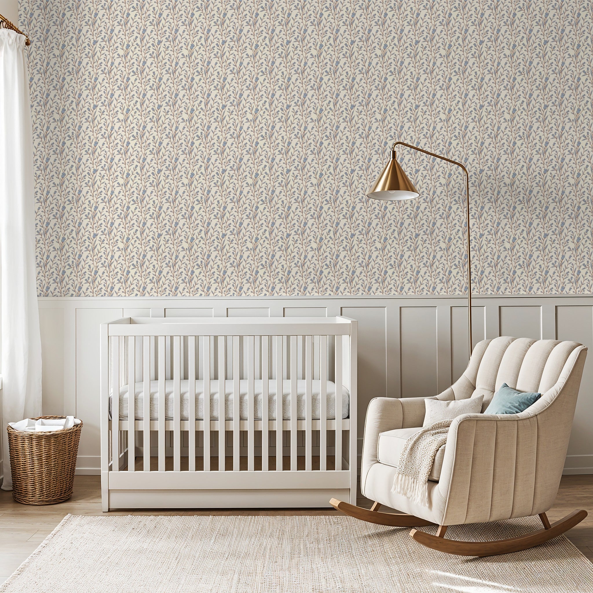 Thistle motif wallpaper in blue and brown in a serene nursery with crib and rocking chair.