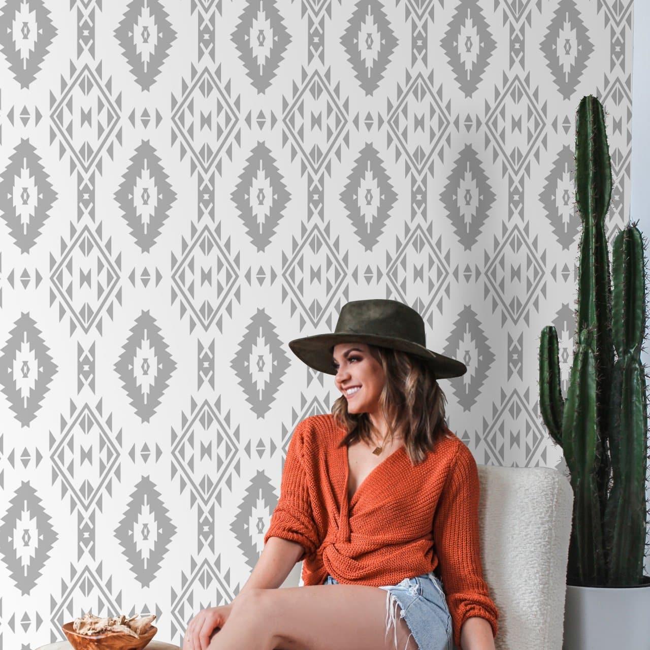 Woman in casual wear enjoying the stylish YEEHAWT (Light) Wallpaper by The MB Line in a cozy living room.
(Note: This alt text is crafted to be descriptive and include the product title, brand, and type of room while focusing on the wallpaper. The presence of the person is mentioned to give context to the setting, but the wallpaper remains the focal point of the description.)