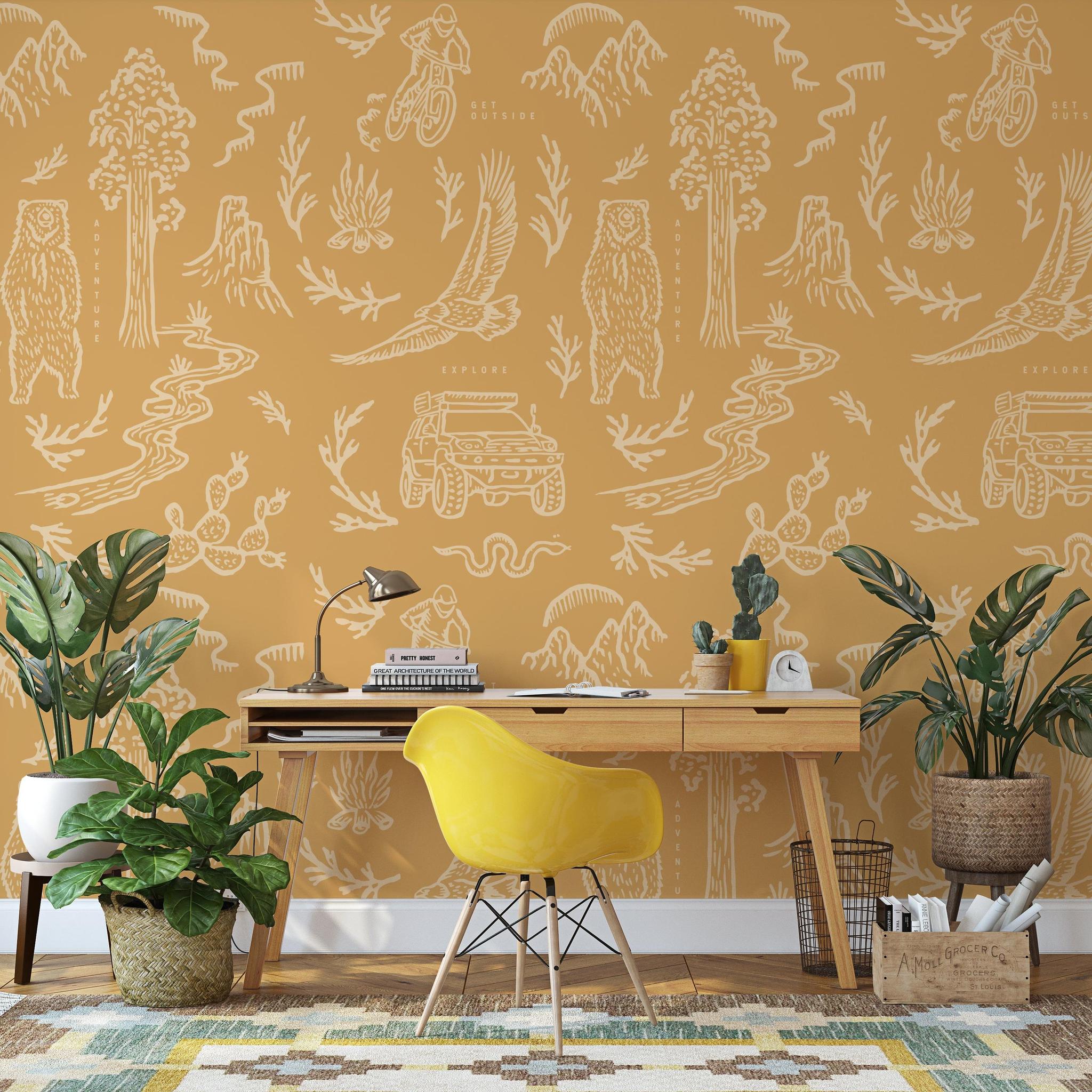 The Rayco Line 'Adventure Awaits (Orange) Wallpaper' in a modern home office setup focused on vivid wall decor.