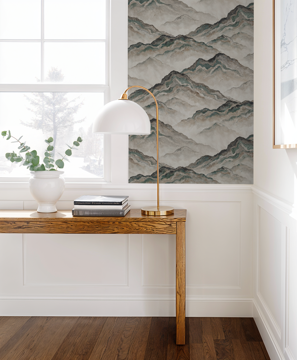 Aurith mountain wallpaper in earth tones with wooden table and lamp in bright room.