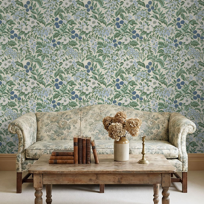Floral wallpaper with blue and green botanical pattern in cozy living room setting.