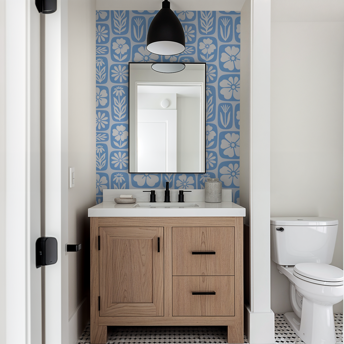 Blue floral wallpaper with white silhouettes in modern bathroom setting.