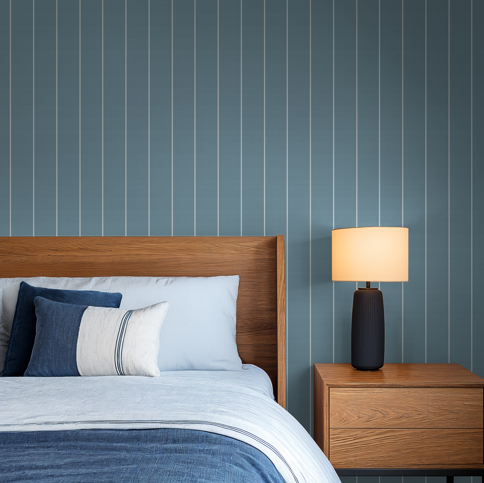 Blue pinstripe dot wallpaper in modern bedroom with wooden bed and lamp.