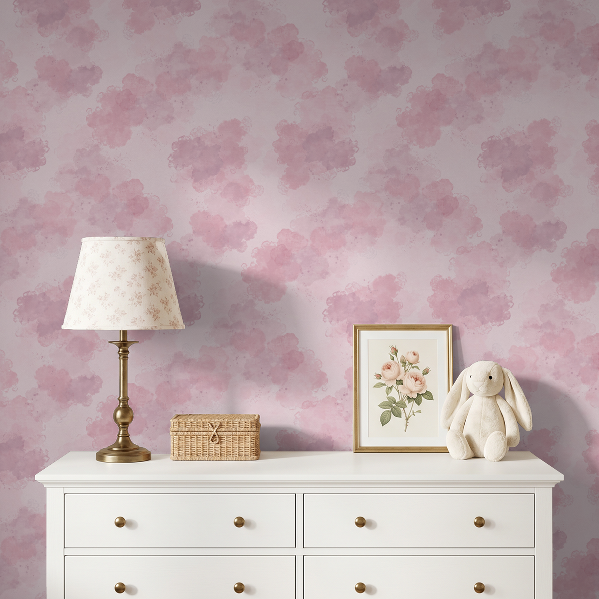 Blush pink watercolor cloud wallpaper in serene nursery with white dresser.