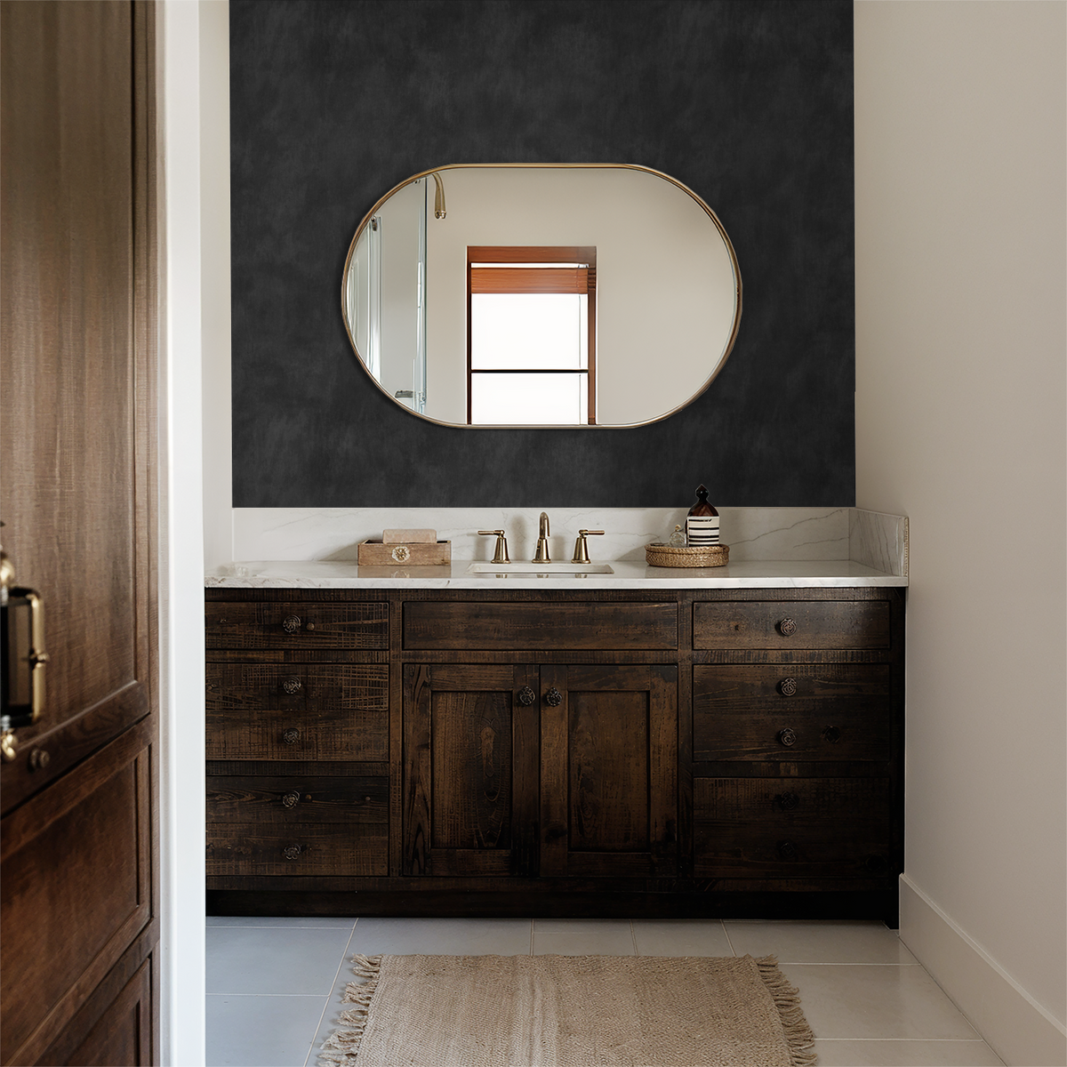 Charcoal limewash wallpaper in elegant bathroom with wooden vanity and oval mirror.