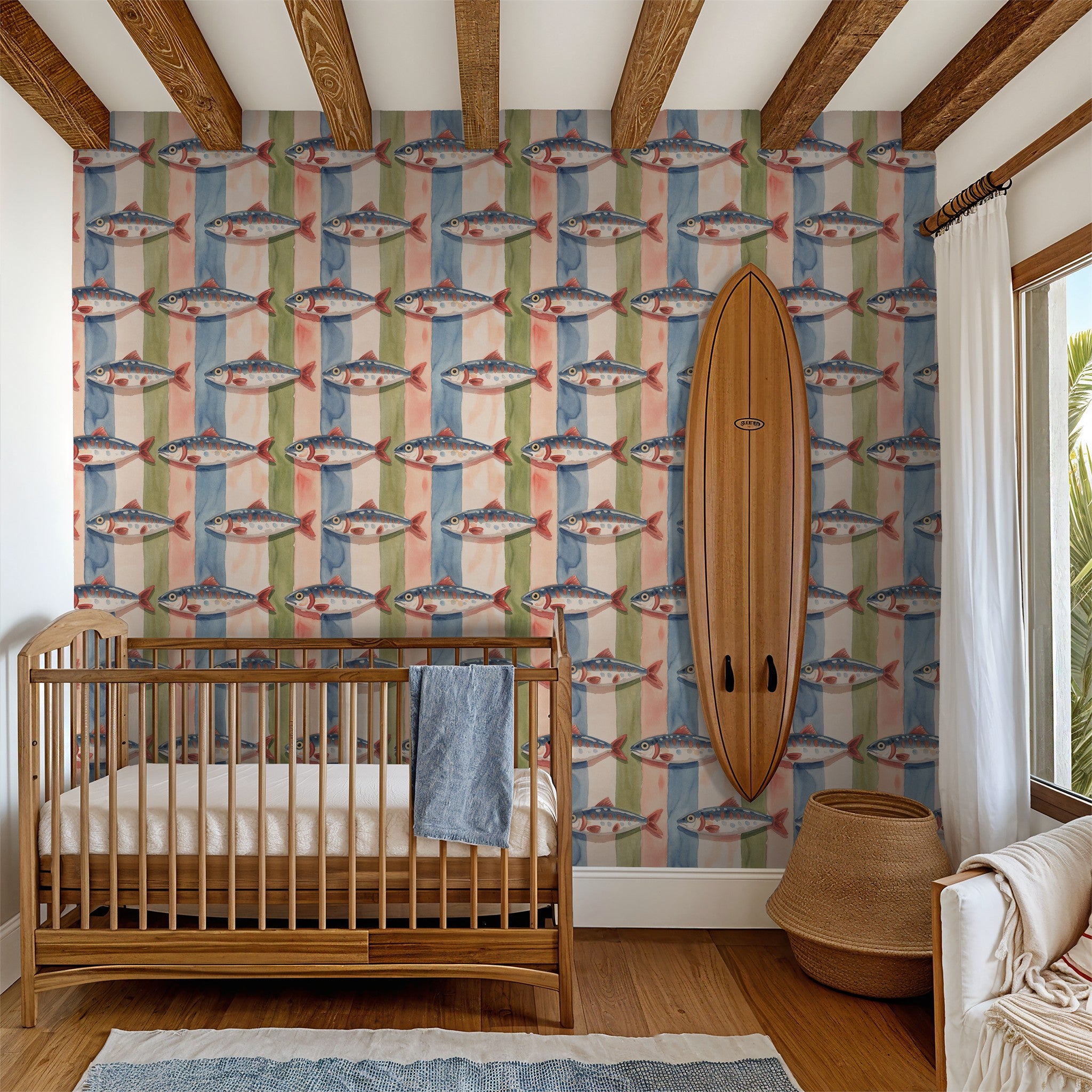 Coastal fish pattern wallpaper with watercolor stripes in a nursery with crib and surfboard.