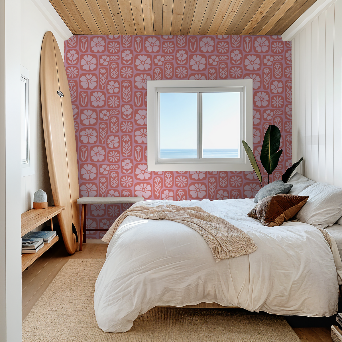 Coral floral wallpaper in a cozy bedroom with a surfboard and ocean view.