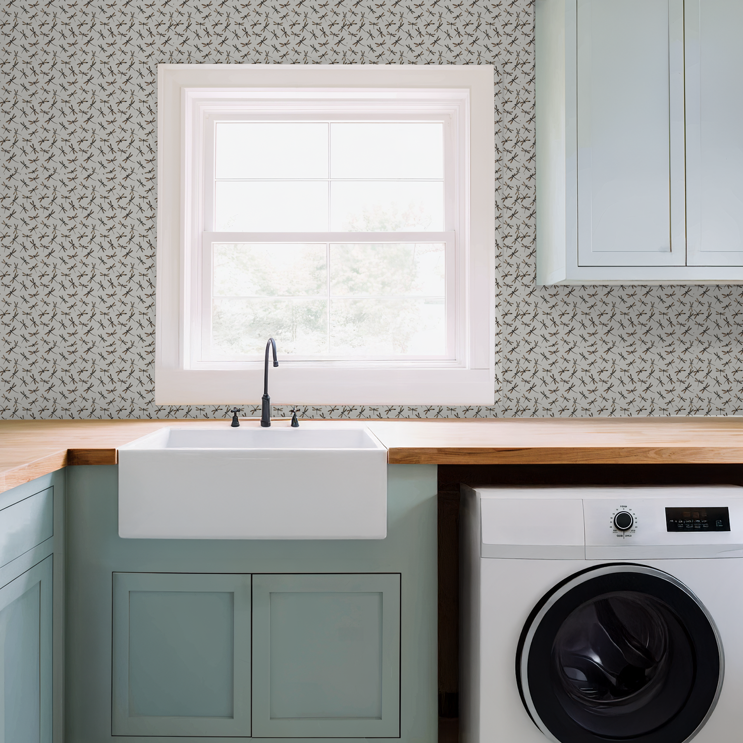 Cream dragonfly pattern wallpaper in a modern laundry room with sink and cabinets.
