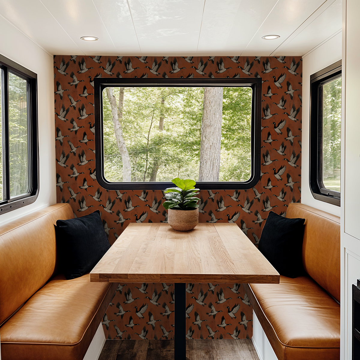 Crimson wallpaper with flying geese pattern in cozy dining nook with leather seating.