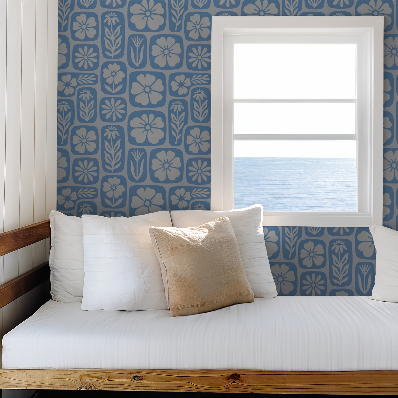Floral blue wallpaper with white silhouettes in a bright room with ocean view.