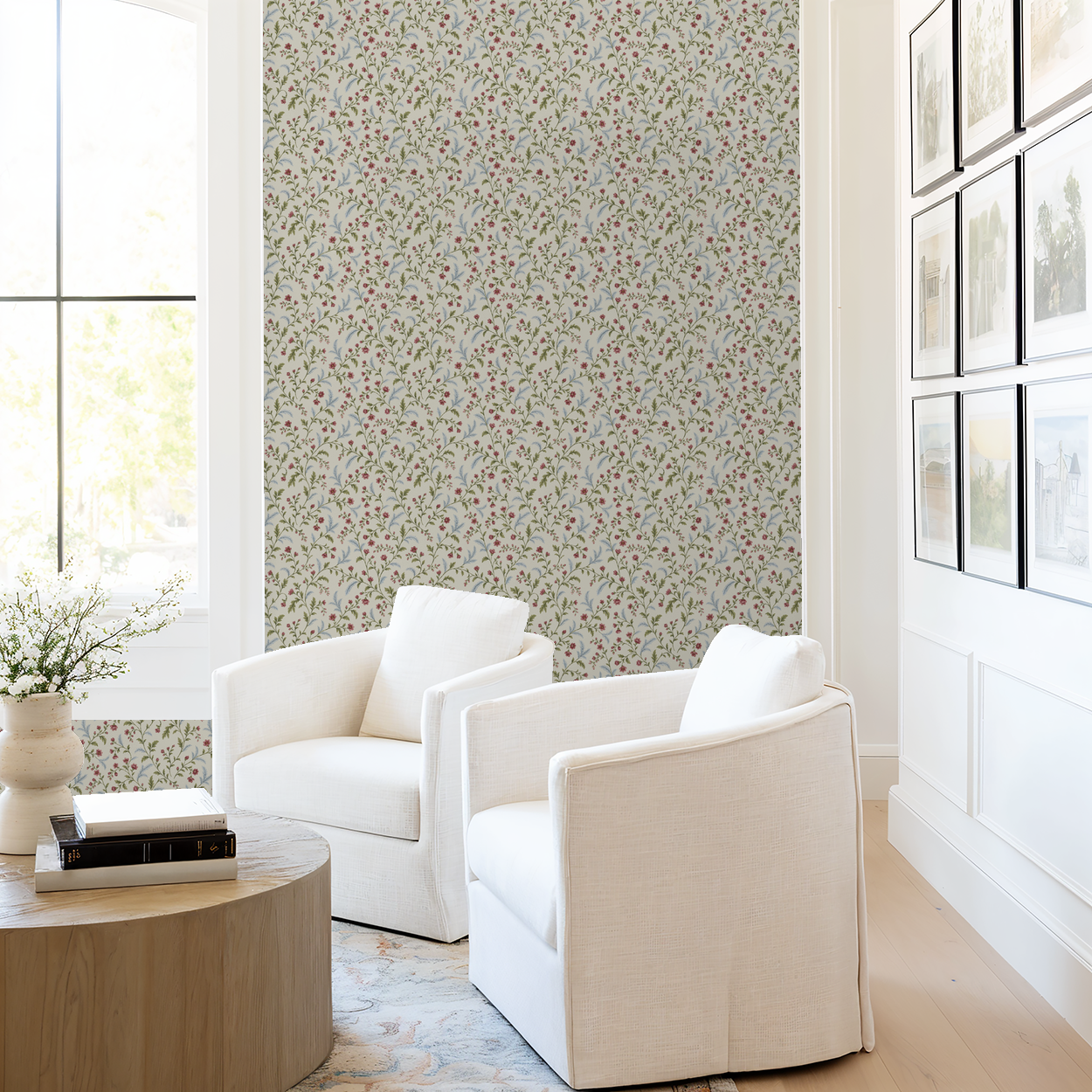 Floral wallpaper with cream, green, and pink pattern in a bright living room with white chairs.