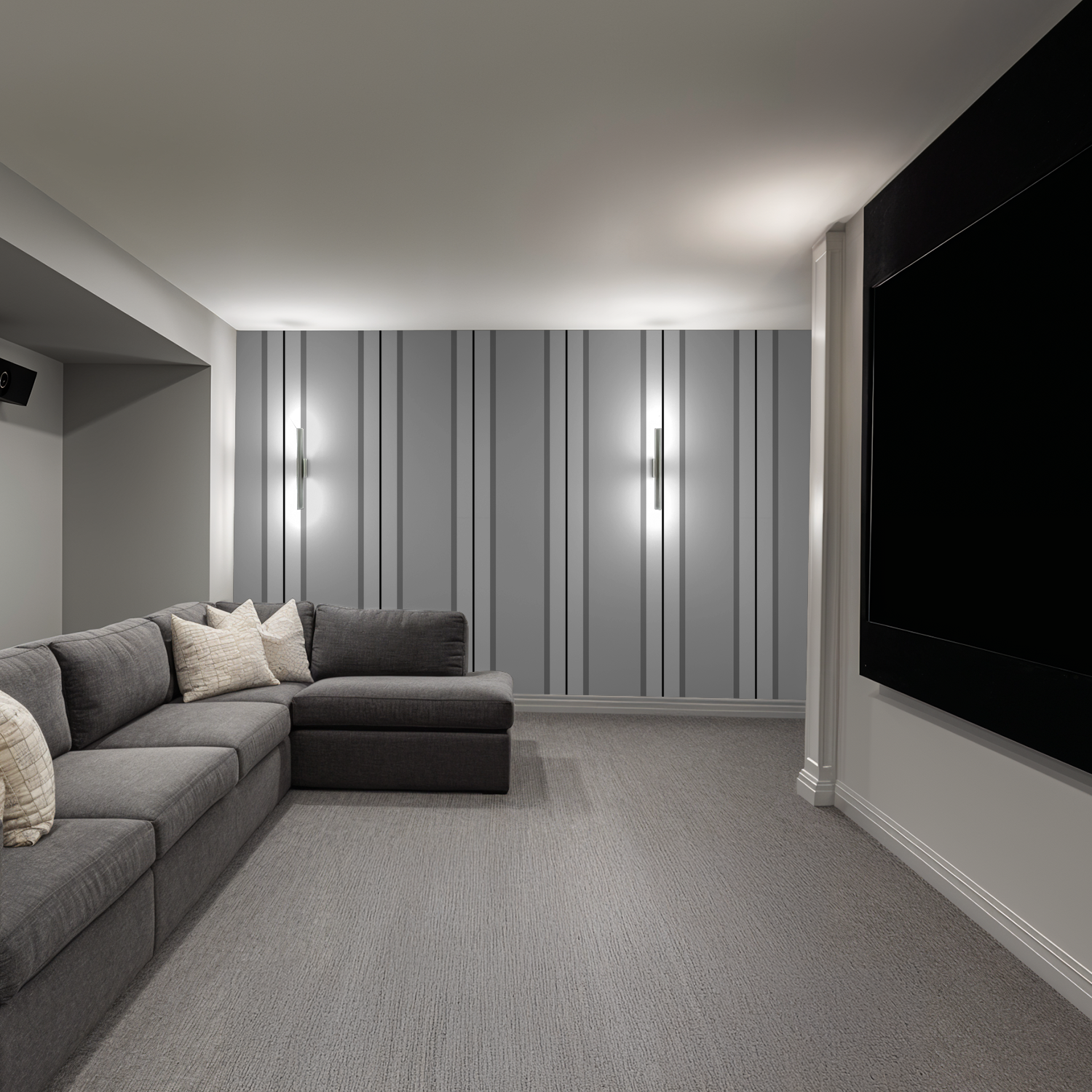 Gray striped wallpaper in modern living room with sectional sofa and wall lights.