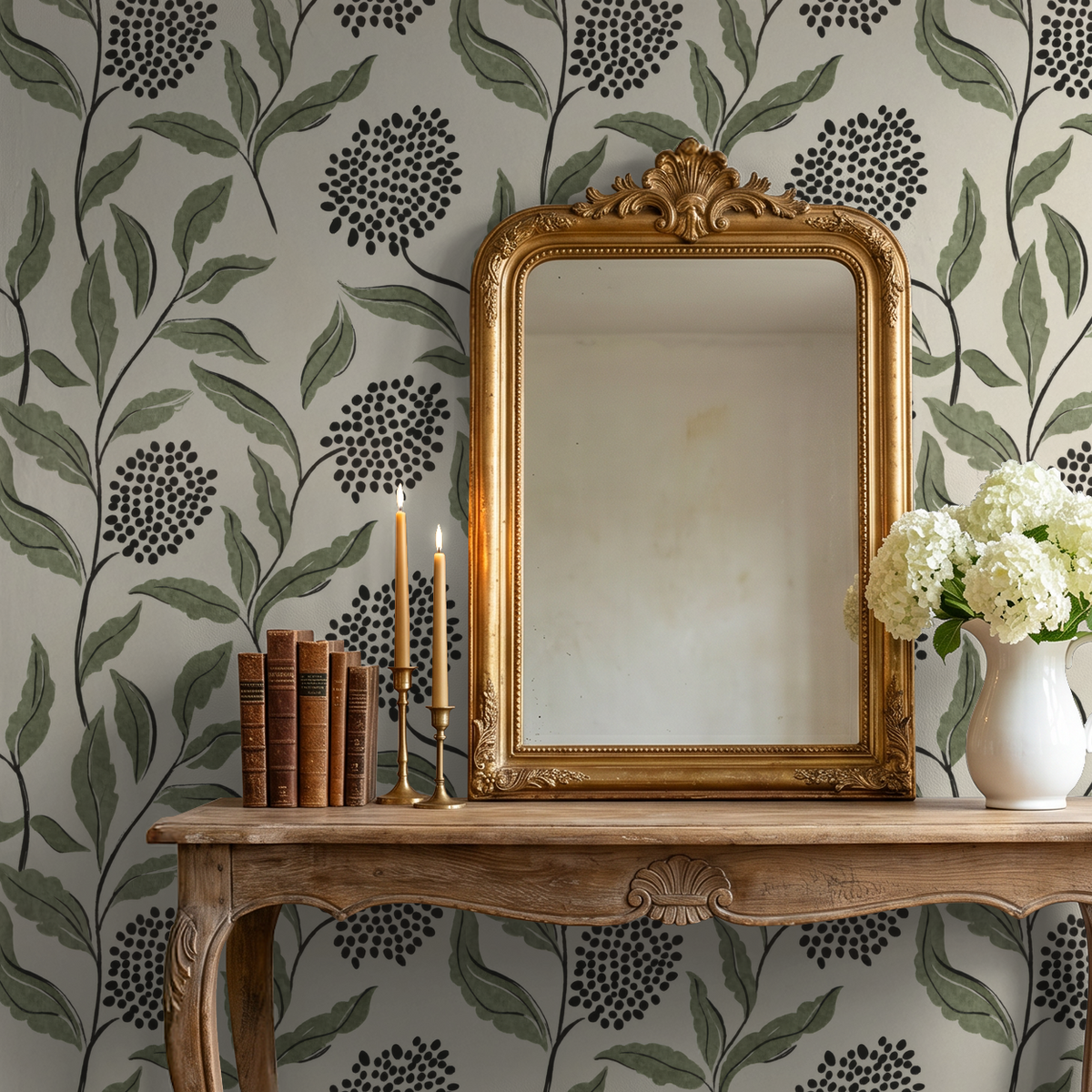 Green botanical wallpaper with sage leaves and charcoal dots in elegant room with mirror and flowers.