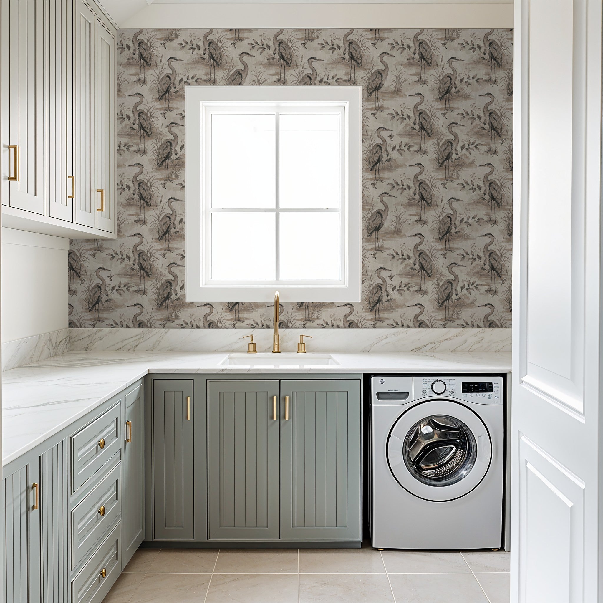 Heron Lake wallpaper with herons and foliage in taupe tones in laundry room.