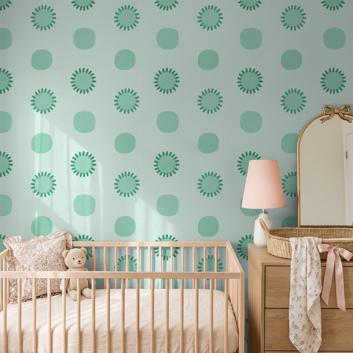 Mint circular patterned wallpaper in cozy nursery with crib and dresser.