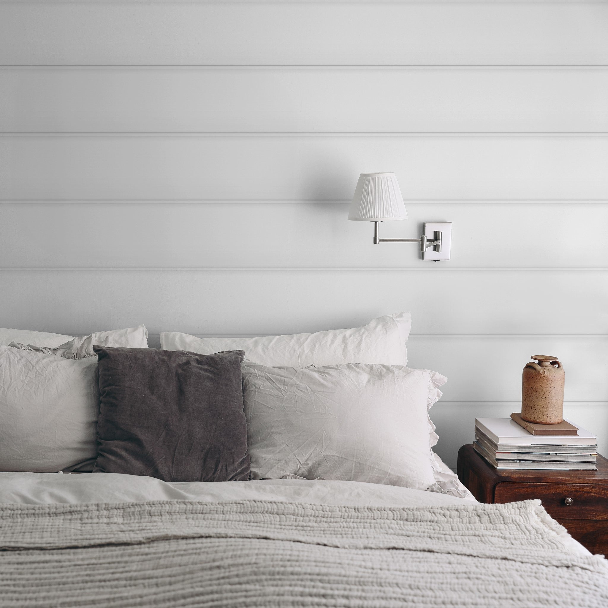 "Cozy bedroom featuring Wall Blush's Anniston Wallpaper with elegant horizontal lines."