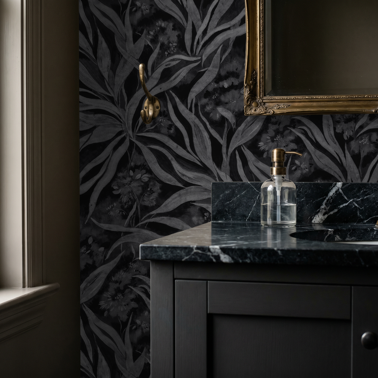 Monochrome foliage wallpaper in elegant bathroom with dark vanity and gold mirror.