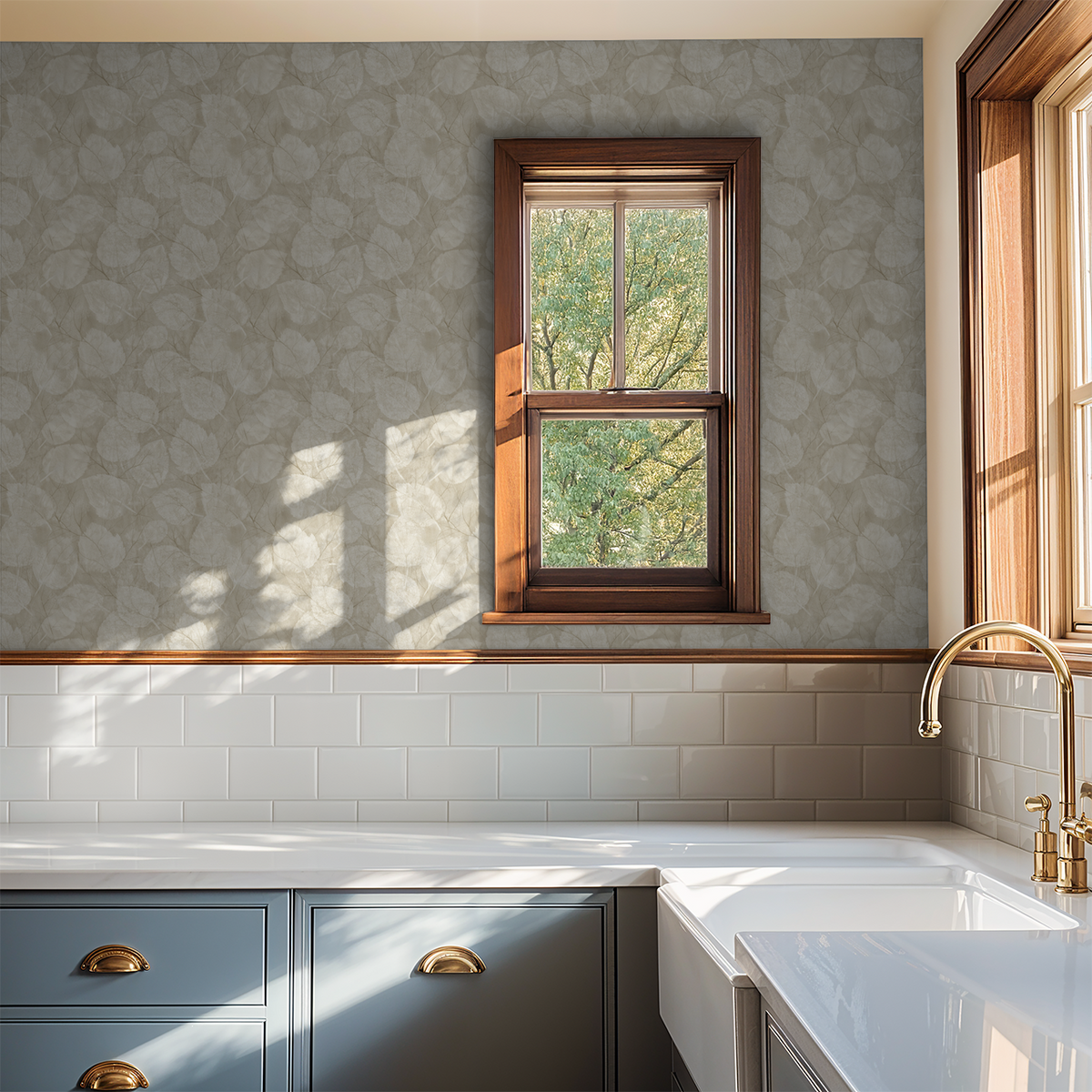 Muted leaf pattern wallpaper in a kitchen with blue cabinets and wooden window frame.