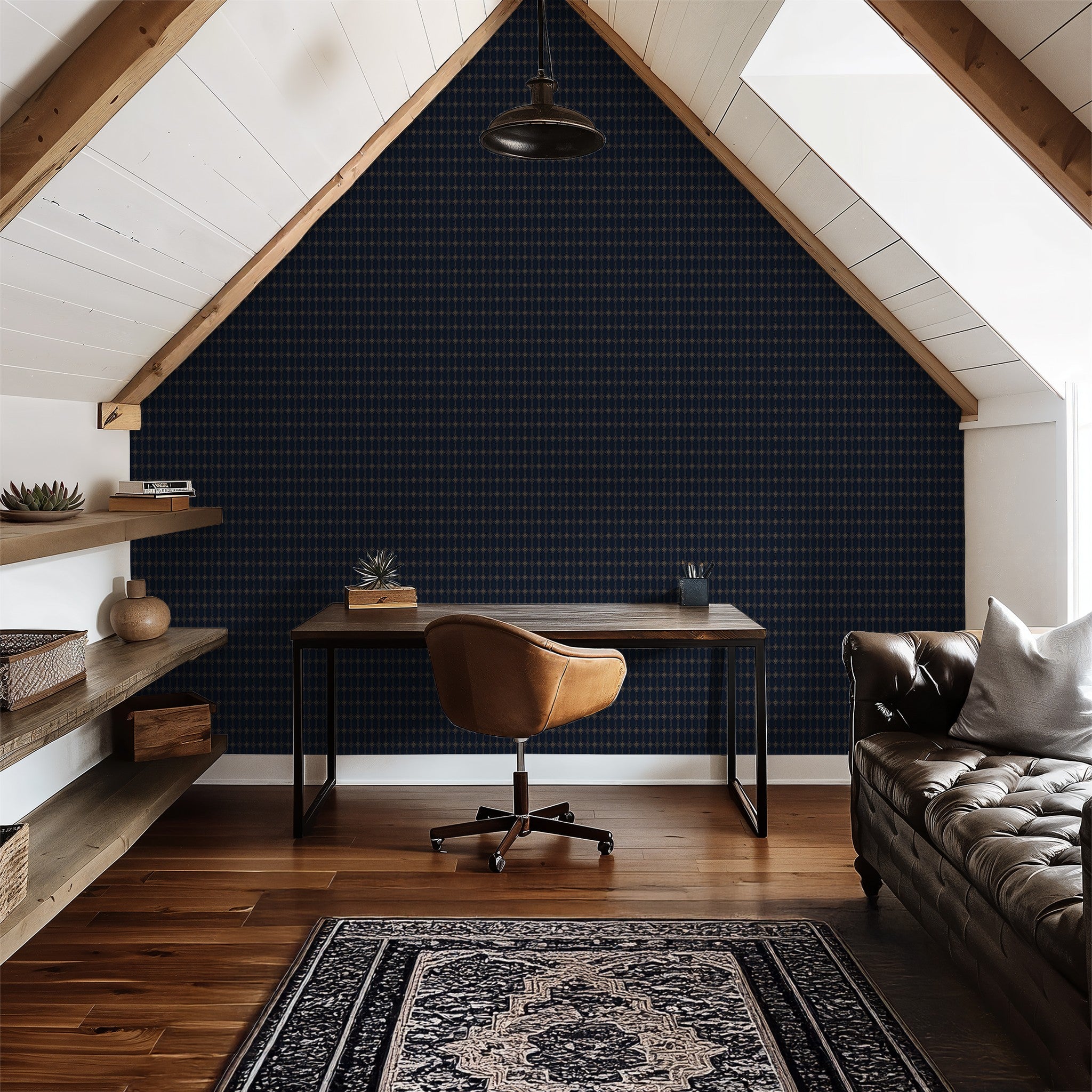 Navy and gold geometric wallpaper in cozy attic office with leather chair and sofa.