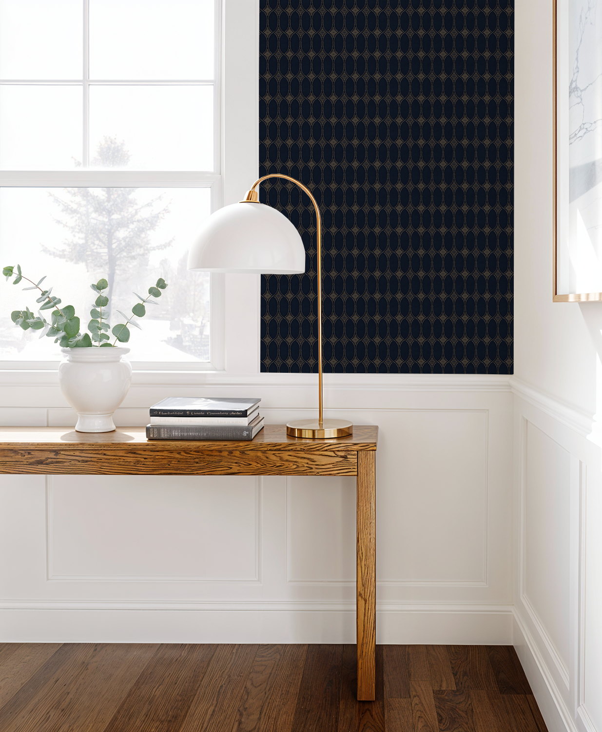 Navy and gold geometric wallpaper in elegant room with wooden table and lamp.