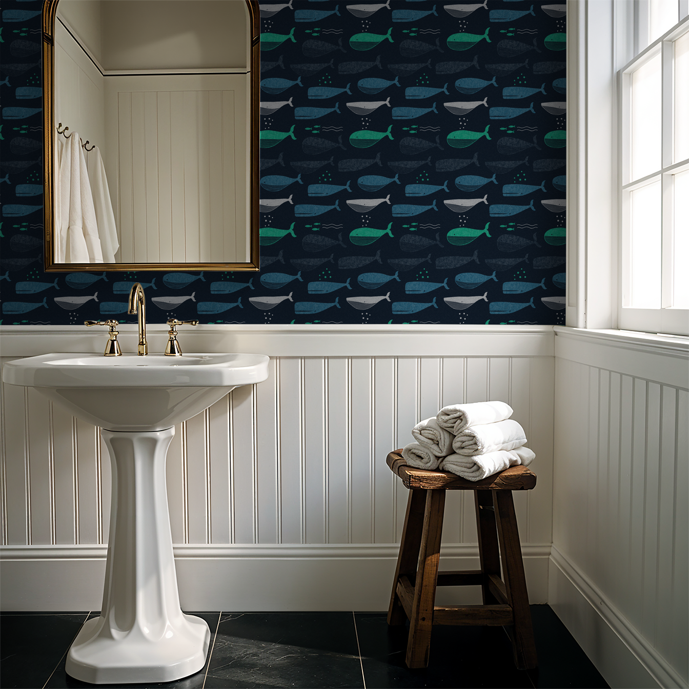 Navy whale wallpaper in bathroom with pedestal sink and mirror.