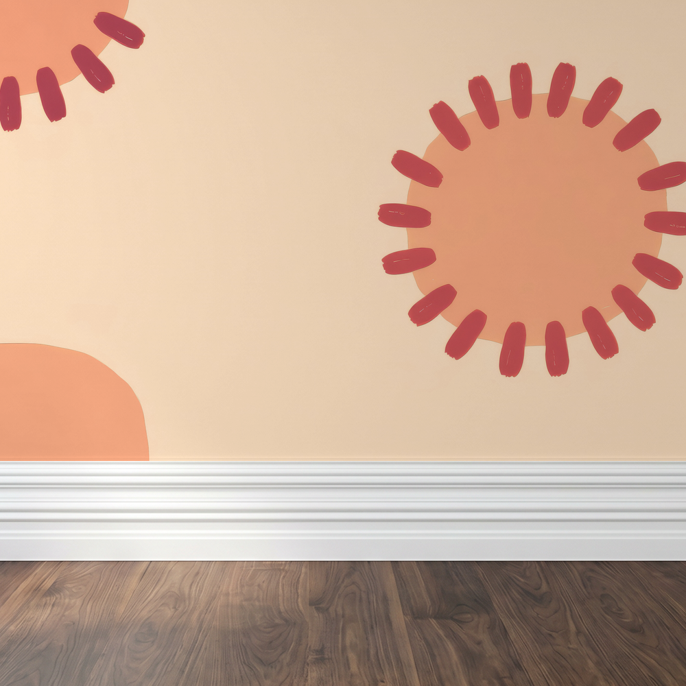 Peach wallpaper with sunburst motifs on a wall above wooden floor