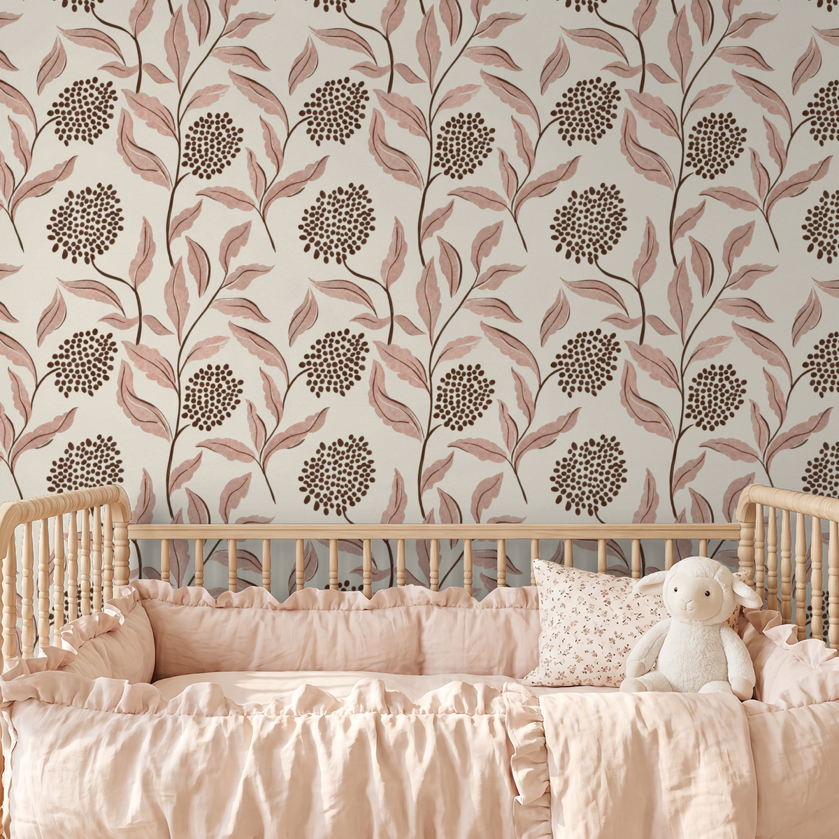 Pink botanical wallpaper with leaves and berries in a nursery with a wooden crib.