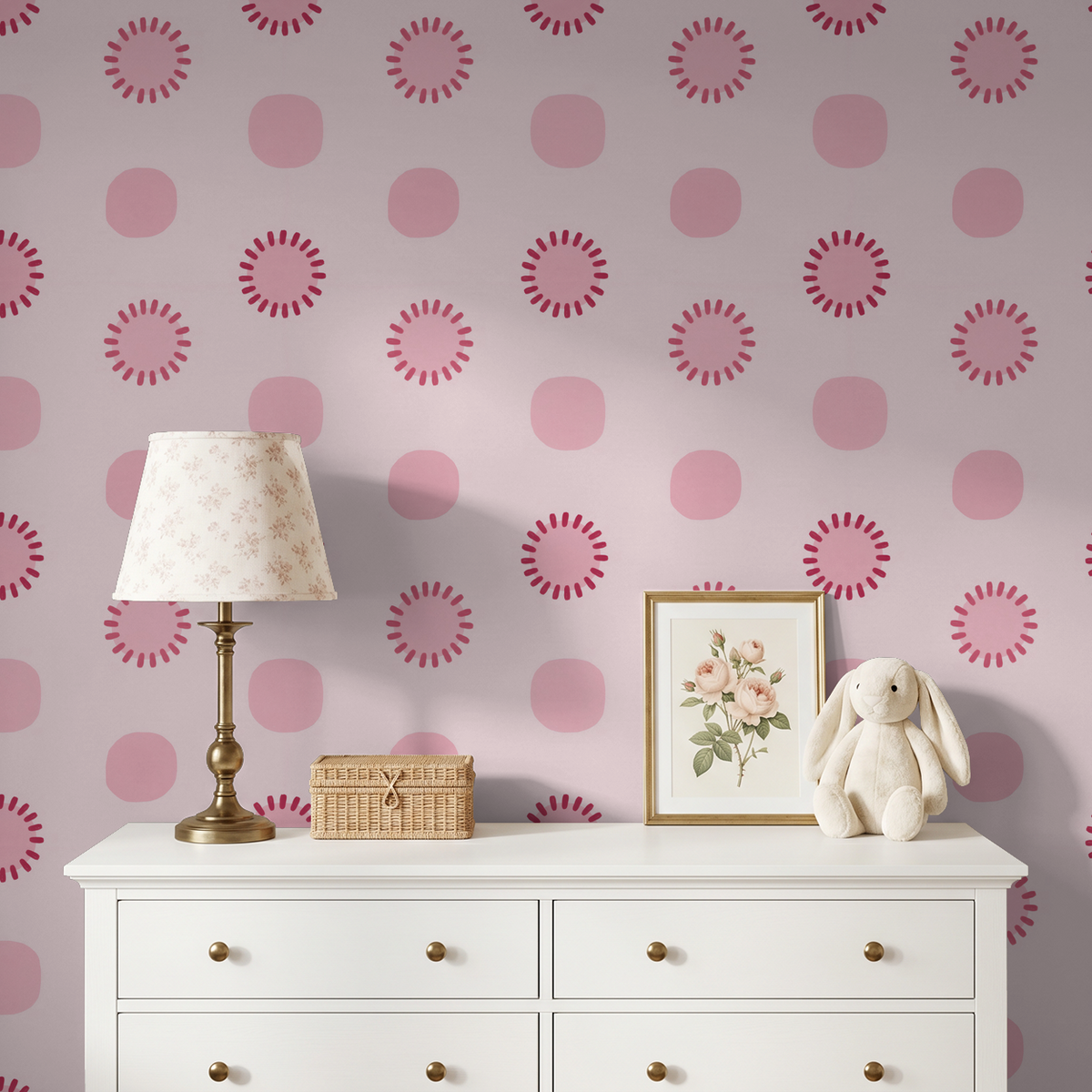Pink circle dot wallpaper in a child's room with white dresser and decor.