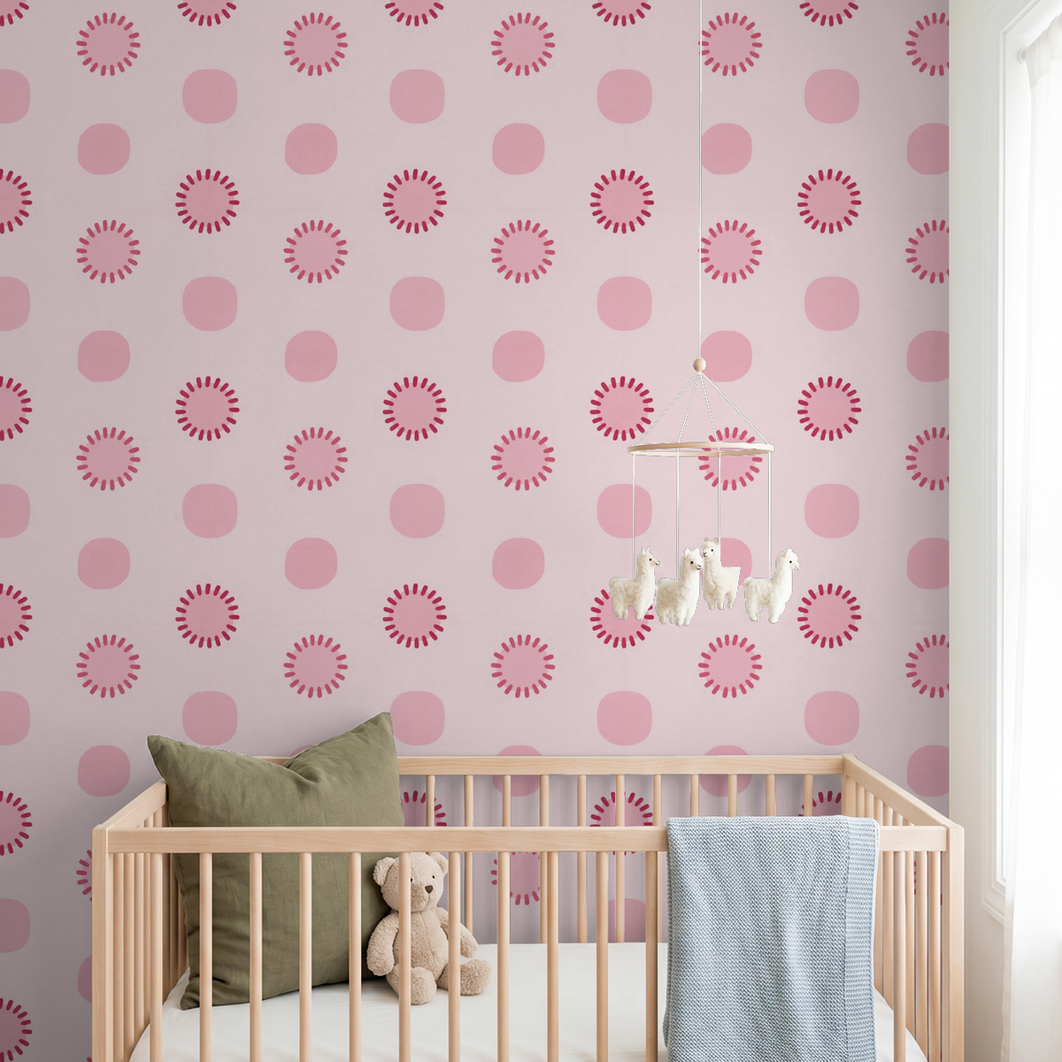Pink circle dot wallpaper in a nursery with crib and stuffed animals.