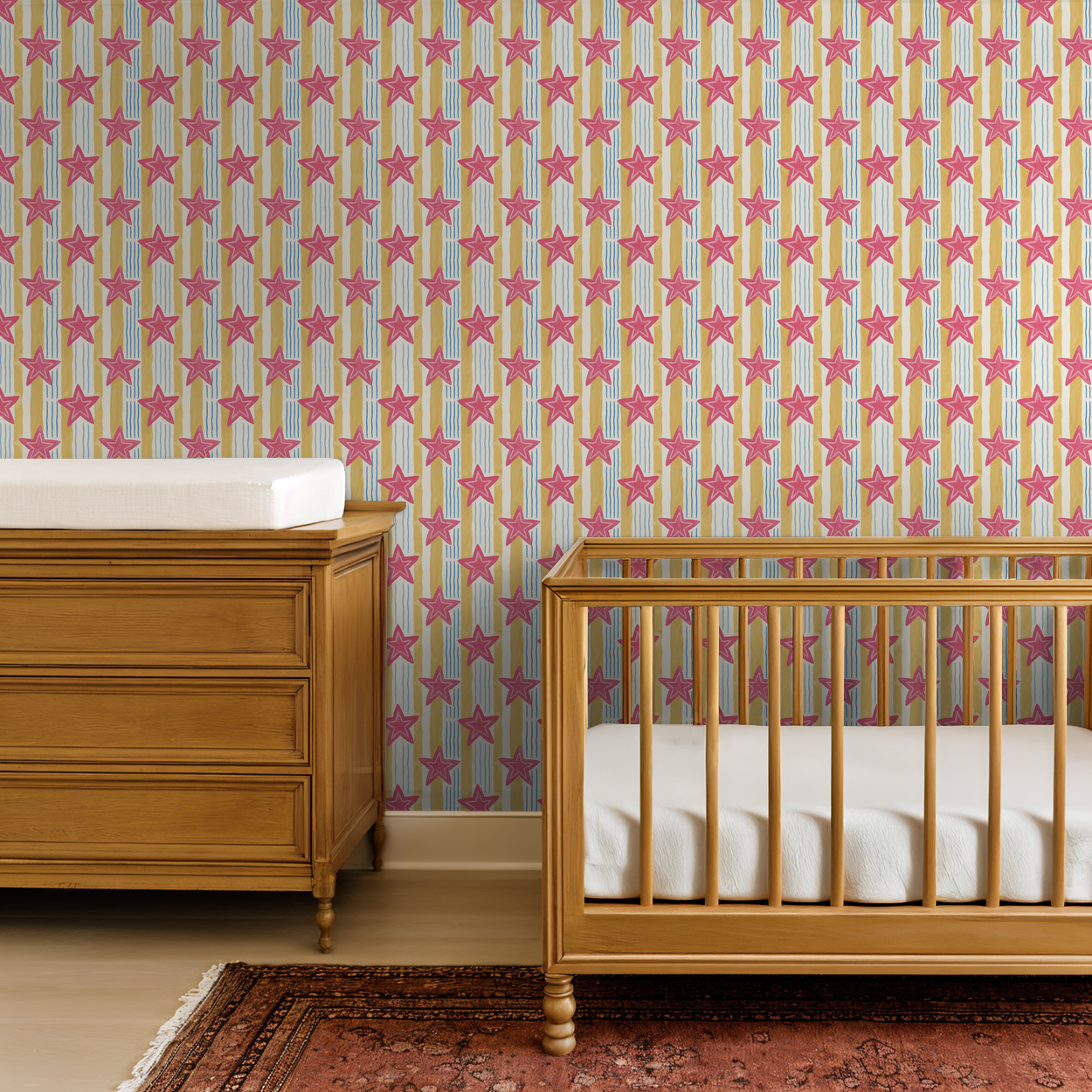 Pink star wallpaper with yellow and blue stripes in a nursery with wooden crib.