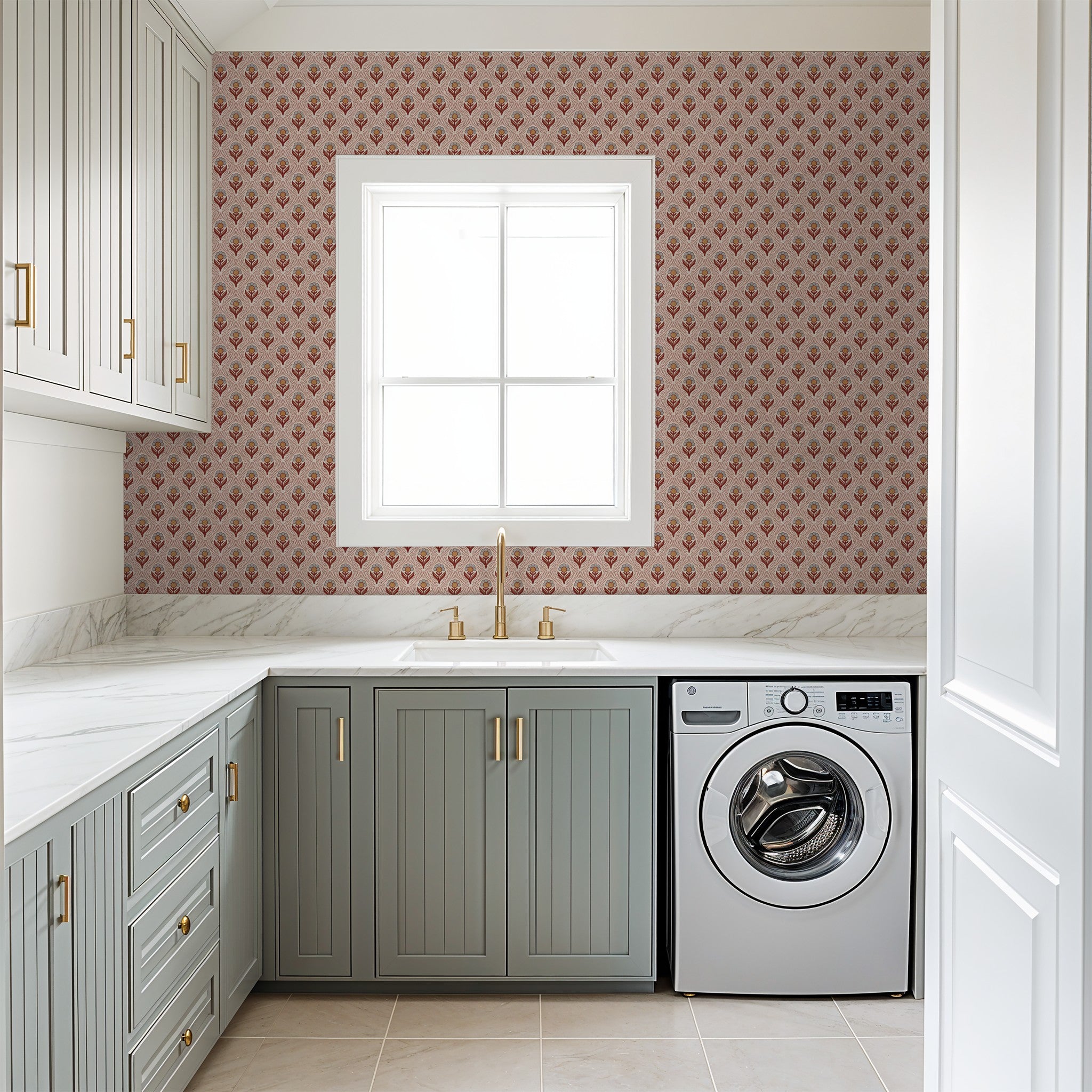 Rust and ochre floral wallpaper in modern laundry room with gray cabinets.
