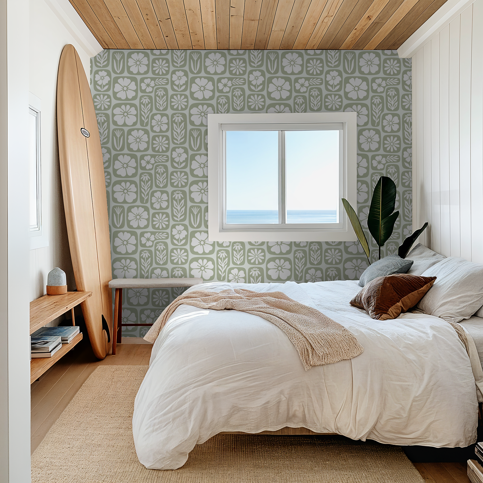 Sage green floral wallpaper in serene bedroom with surfboard and ocean view.